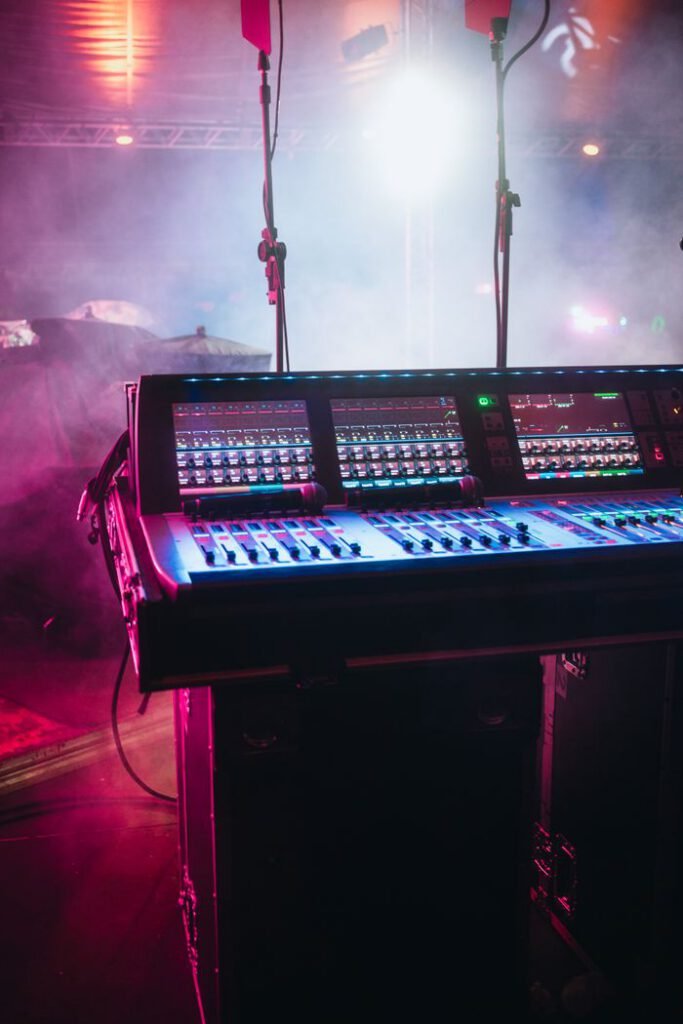 pexels photo 12262186 A vibrant shot of a professional audio mixer on a stage under colorful lights, ready for a live performance.